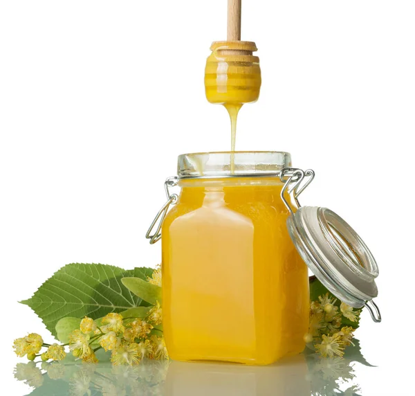Pramínek přírodního medu, tekoucí ze lžíce, Lindenovy květy, izolované na bílém — Stock fotografie
