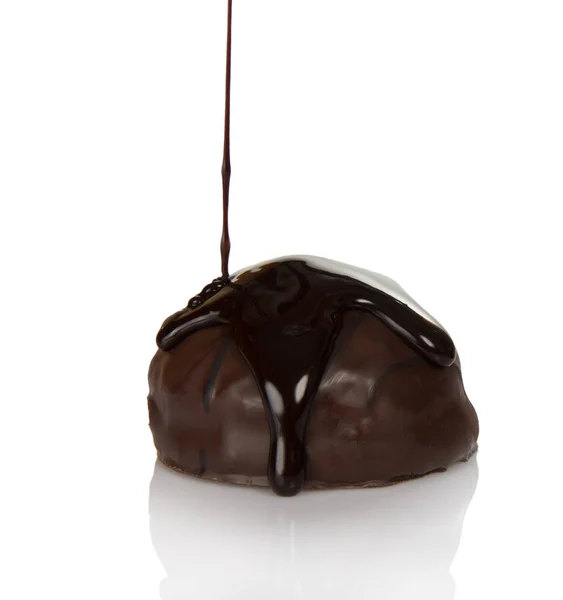 Härligt godis med pralin, i strömmar av smält choklad isolerad på vitt — Stockfoto