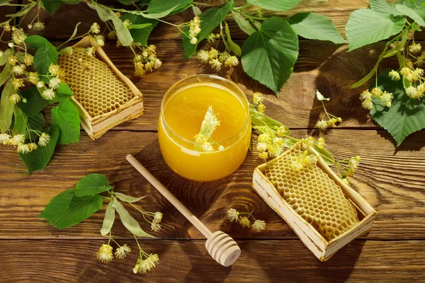 Jar of linden honey, honeycombs and spoon on table — Stock Photo, Image