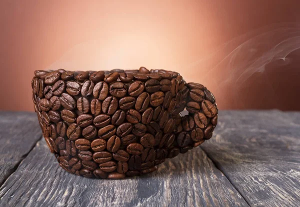 Coupe faite de grains de café se tient sur une table en bois — Photo
