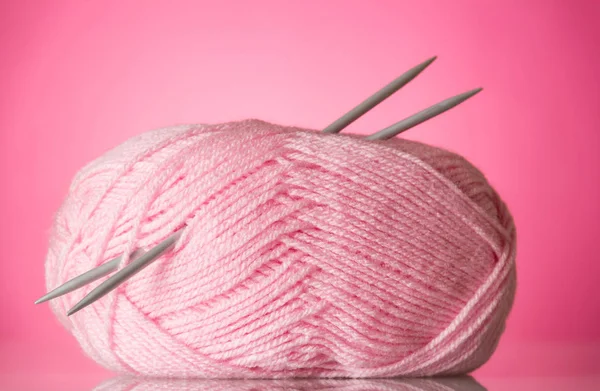 Club of soft, fluffy pink yarn and knitting needles, on pink — Stock Photo, Image