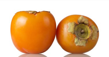 Hurma, beyaz arka planda izole edilmiş iki büyük portakal meyvesi.