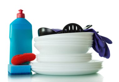 Temiz tabaklar, bir şişe deterjan, beyaz arka planda izole edilmiş iş eldivenleri ve süngerler.