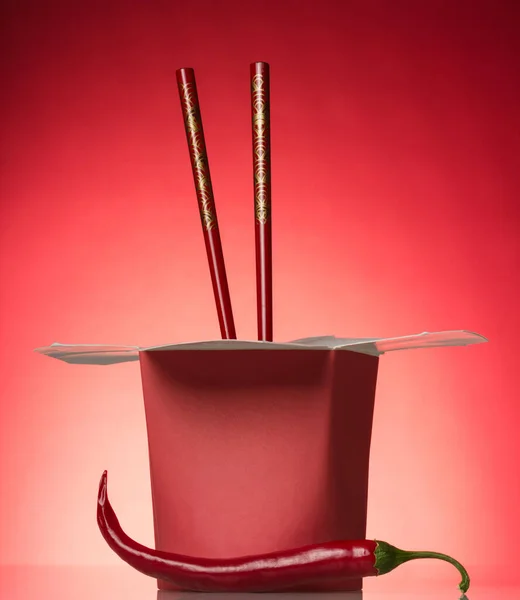 Otwarty Pojemnik Gorącym Jedzeniem Pałeczkami Papryką Chili Czerwonym Tle — Zdjęcie stockowe