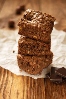 Peçeteli, çikolatalı, tahta yüzeyli fındıklı kek parçaları.