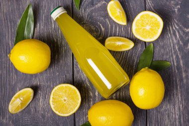 Tüm limonlar, meyve dilimleri ve meyve suyu koyu ahşap yüzeyde.