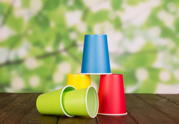 Set Multicolored Plastic Cups Brown Wooden Table — Stock Photo, Image