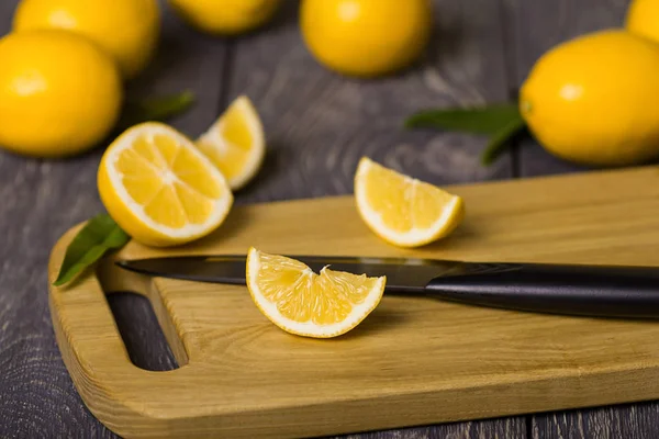 Ganze Zitrusfrüchte Geschnittene Zitronenscheiben Und Messer Auf Schneidebrett Auf Holztisch — Stockfoto