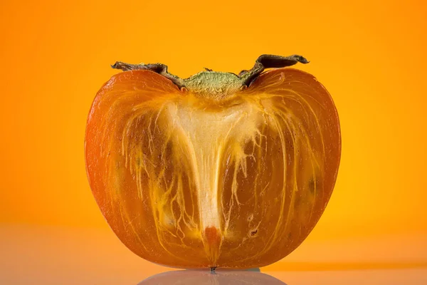 Mezza Frutta Matura Cachi Sfondo Arancione Brillante — Foto Stock