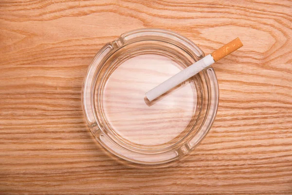 Cigarett Med Filter Ligger Ett Askfat Beige Träyta — Stockfoto