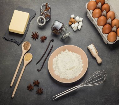 Eggs, butter and flour, a set of tools for kneading the dough, on a gray background