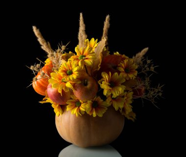 Orjinal elma buketi ve çiçekler kabak vazosunda, siyah arka planda izole edilmiş.