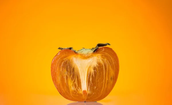 Metade Dos Frutos Maduros Cáqui Sobre Fundo Laranja — Fotografia de Stock