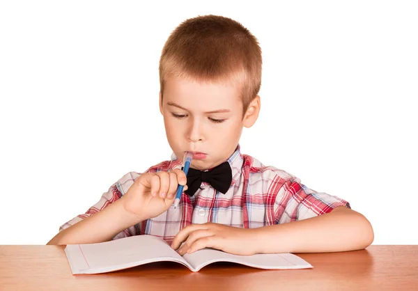 Boy Skriver Anteckningsbok Sitter Vid Skrivbordet Isolerad Vit Bakgrund — Stockfoto