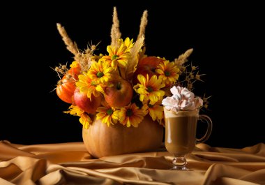 Orijinal kompozisyonu balkabağı ve kapuçino, ipek kumaş üzerine marşmelov, siyah arka planda izole.