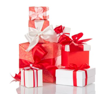 Beyaz arka planda kırmızı ve beyaz fiyonklarla süslenmiş parlak hediye kutuları yığını