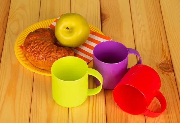 Tres Copas Plástico Colores Croissant Una Manzana Plato Fondo Mesa —  Fotos de Stock