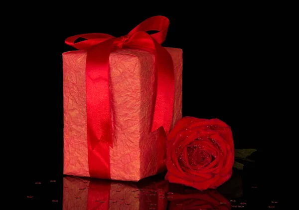 礼盒上有蝴蝶结 红玫瑰上有水滴 与黑色背景隔离 — 图库照片