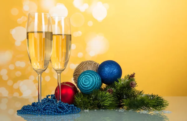 Şampanyalı Iki Bardak Parlak Yeni Yıl Oyuncakları Açık Sarı Arka — Stok fotoğraf