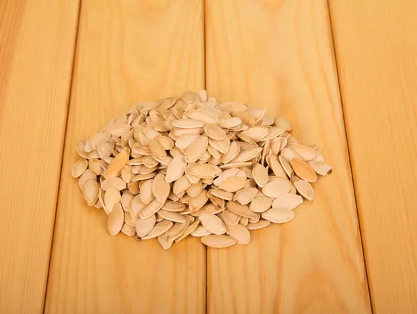 Une Poignée Graines Citrouille Sèches Repose Sur Une Table Bois — Photo