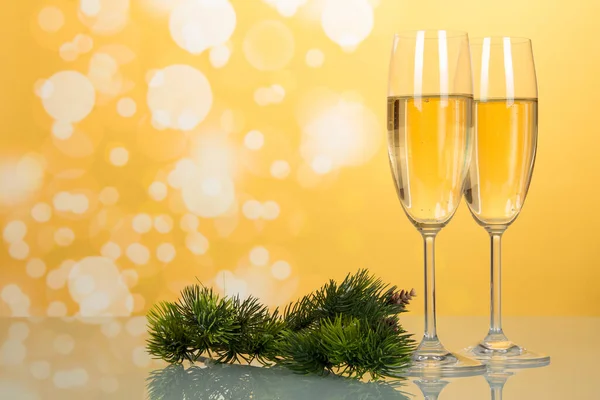 明るい黄色の背景にシャンパン 新年の松の枝を持つ眼鏡 — ストック写真