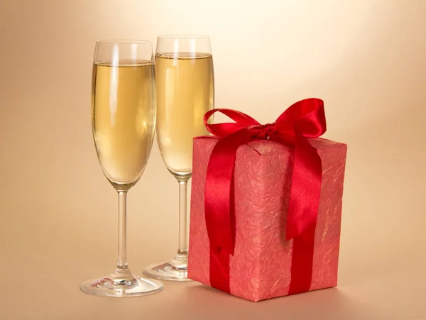 Christmas Gift Red Box Bow Two Glasses Champagne Beige Background — Stock Photo, Image