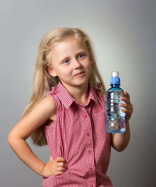 魅力的なブロンド女の子保持ボトルの水で手で灰色の背景 — ストック写真