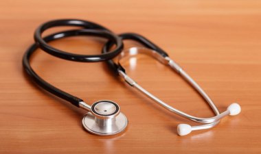 Tahta masanın arka planında tıbbi teşhis aracı, steteskop.