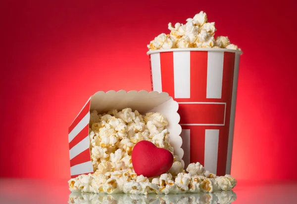 Large box and sprinkled snack, heart on a bright red background