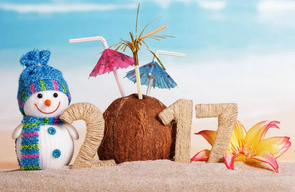 圣诞雪人 带着雨伞的椰子 以及2017年在沙滩上与大海相对的题词 — 图库照片