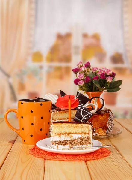 巧克力奶油蛋糕 一杯茶 厨房后面的蜡烛 — 图库照片
