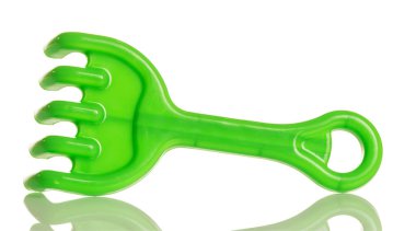 Beyaz arkaplanda izole edilmiş kum havuzunda oynamak için yeşil plastik tırmık.