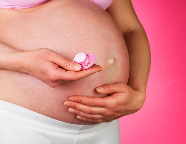 Mujer Embarazada Sosteniendo Chupete Sobre Fondo Rosa — Foto de Stock