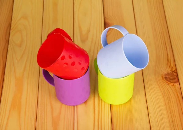 Quatre Tasses Plastique Coloré Sur Fond Bois Clair — Photo