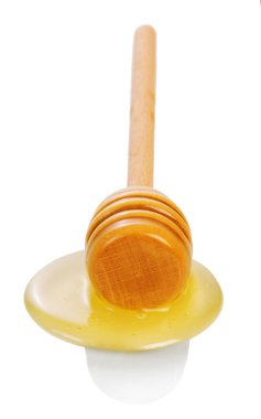 Beyaz arka planda izole edilmiş ahşap kaplamalı bir damla taze bal..