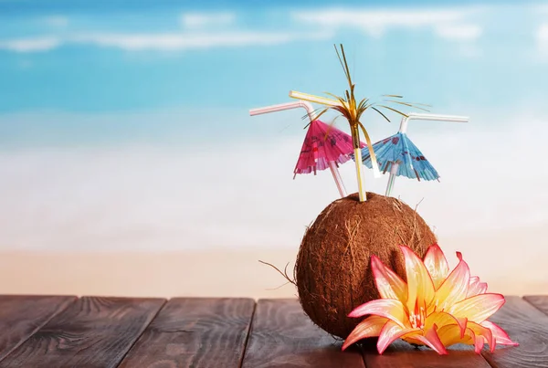 Kokosový Ořech Slaměnými Deštníky Květinami Hnědém Stole Moře — Stock fotografie