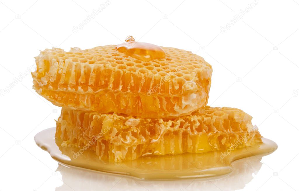 Honeycombs and honey flowing down from the bucket isolated on a white background.