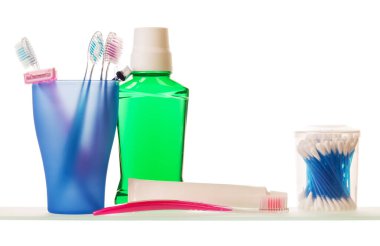 Diş fırçası, tek kullanımlık jilet, diş macunu, iksir ve pamuklu çubuklar beyaz arka planda izole edilmiş..