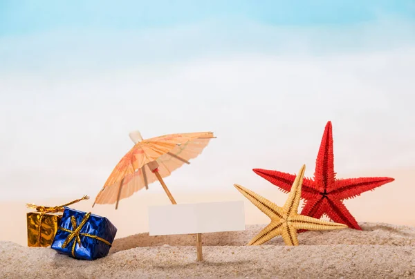 海に対する砂の中の空のカード ヒトデ 傘や贈り物 — ストック写真