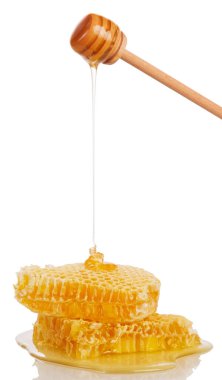 Beyaz arka planda izole edilmiş bir kepçeden bal ve bal akıyor..