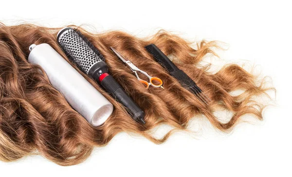 Wavy hair and hairdresser's tools isolated on white background.