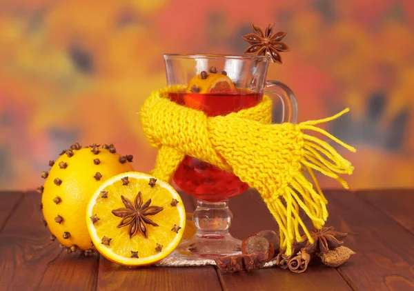 用围巾包裹着的碾碎的葡萄酒 带有丁香和榛子的橙子 背景是秋天的叶子 — 图库照片