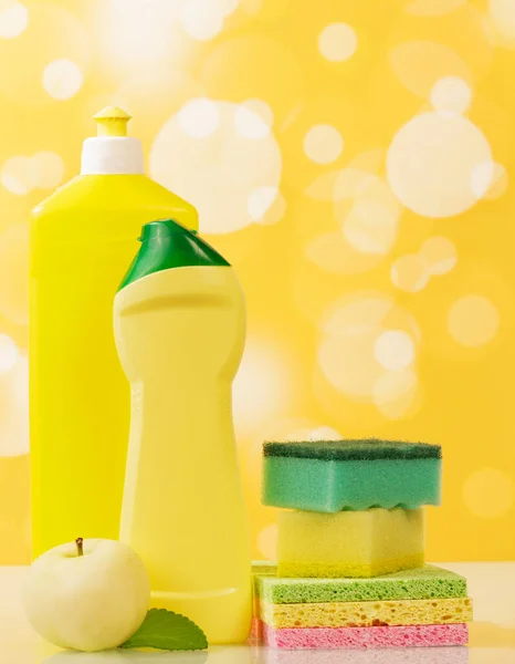Flessen Wasmiddel Spons Appel Een Abstracte Gele Achtergrond — Stockfoto