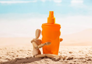 Deniz kıyısında güneş kremi sürmüş ahşap manken..