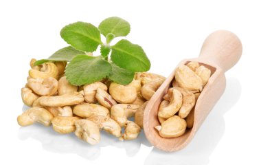 Kavrulmuş fındık ve kepçe, beyaz arka planda izole edilmiş bir nane filizi..