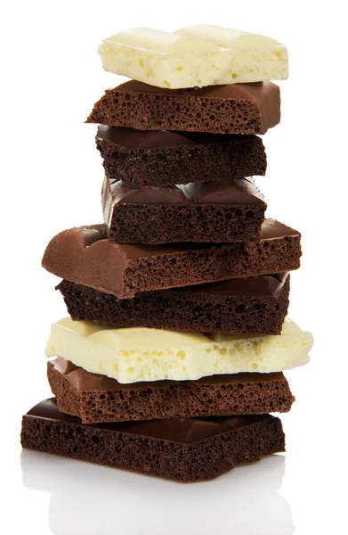 白い背景に隔離された多孔質ミルクと黒チョコレートの異なる部分の塔 — ストック写真