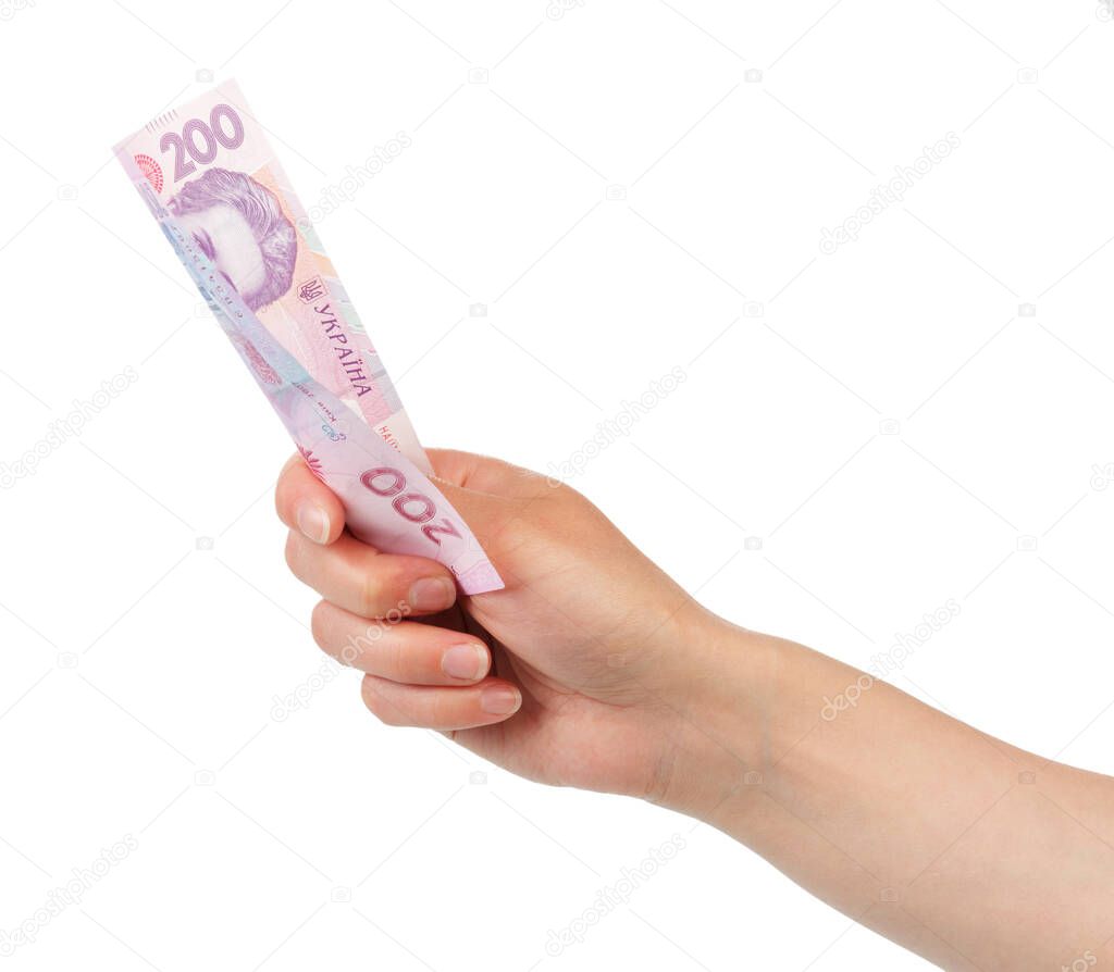 Ukrainian money 200 hryvnia in a female hand isolated on white background.