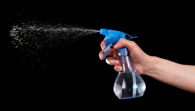 Siyah arka planda izole edilmiş plastik spreyli kadın eli..