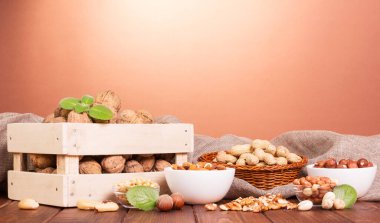 Kahverengi arka planda çeşitli kabuklu fındıklar..