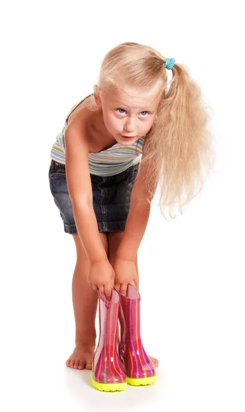 小さなブロンド女の子でスカートとブラウスBrendingダウンホワイトバックで隔離されたゴムブーツを保持 — ストック写真